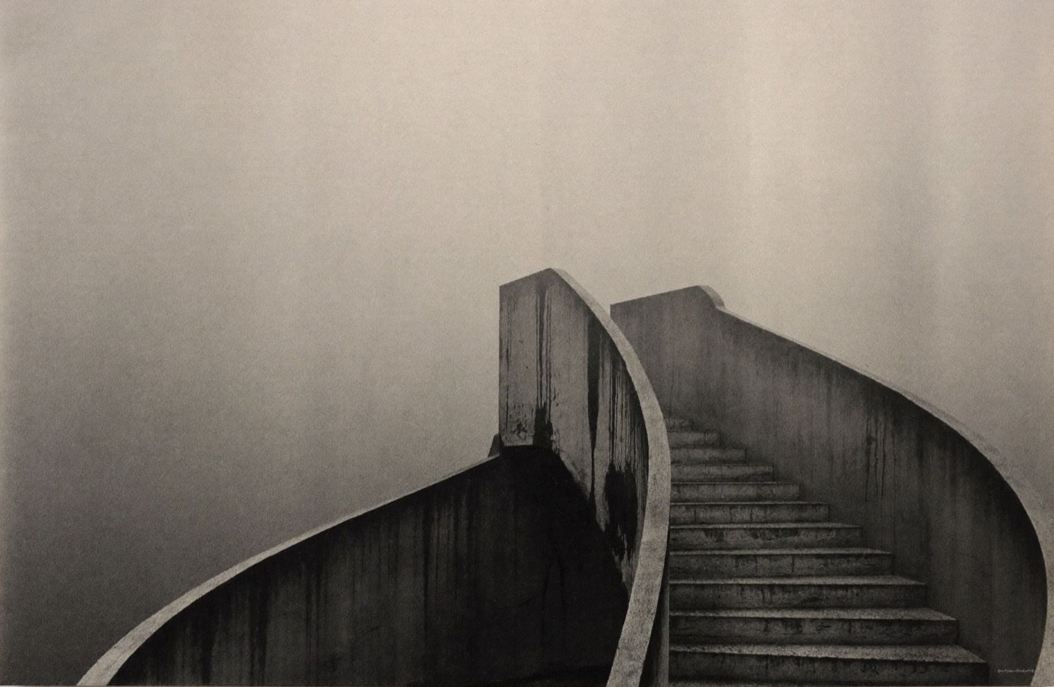 Curved brutalist stairwell in heavy fog